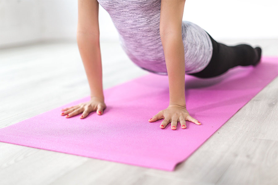 Mujer haciendo yoga en su casa