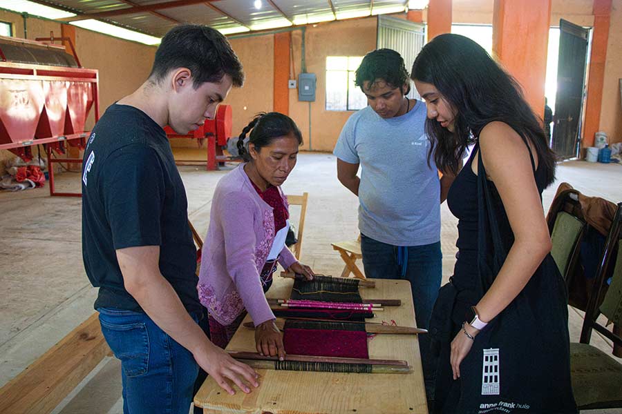 Mujer artesana con estudiantes en Chiapas