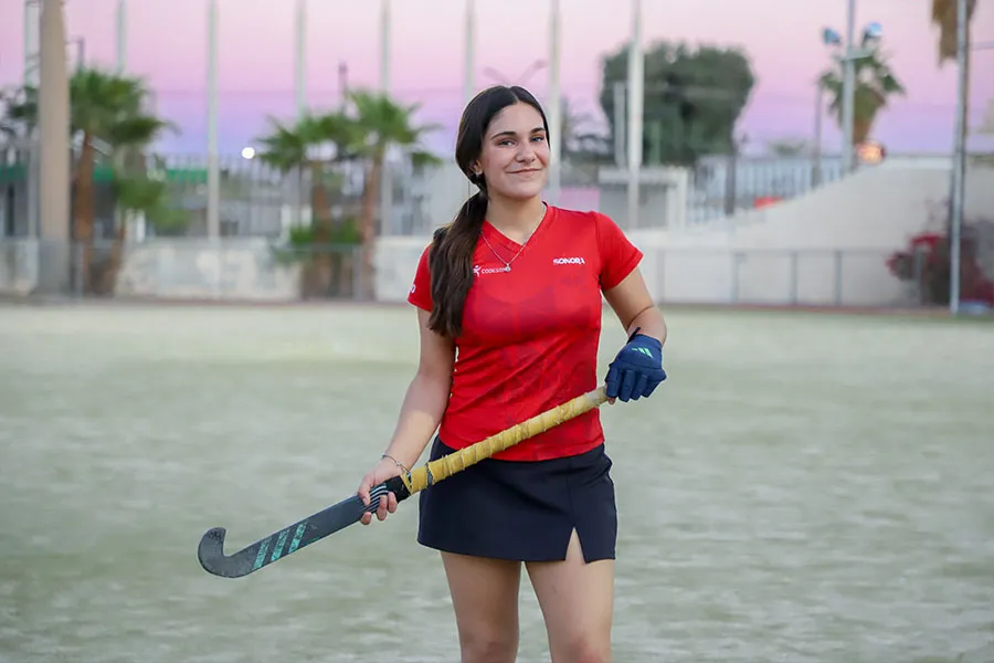 Chica adolescente en campo de hockey sobre pasto con uniforme de Selección Sonora.