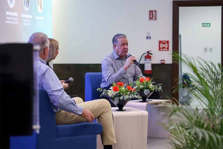 Empresario habla frente a un público en pánel de discusión.