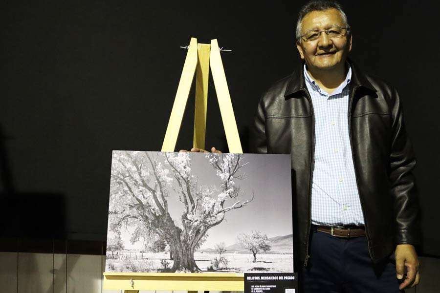 El profesor investigador Mario Manzano posando junto a su fotografía favorita.