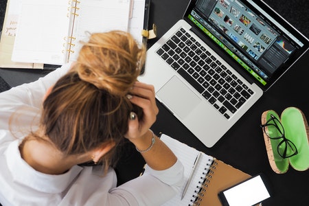 mujer trabajando en una laptop y una libreta