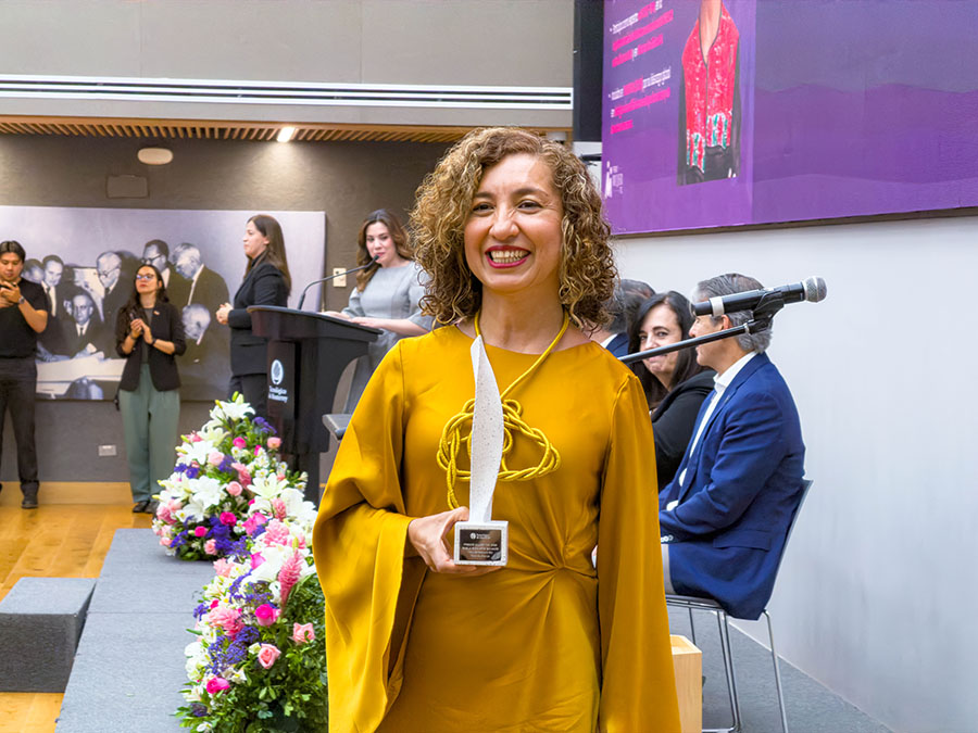 Paola sosteniendo su reconocimiento