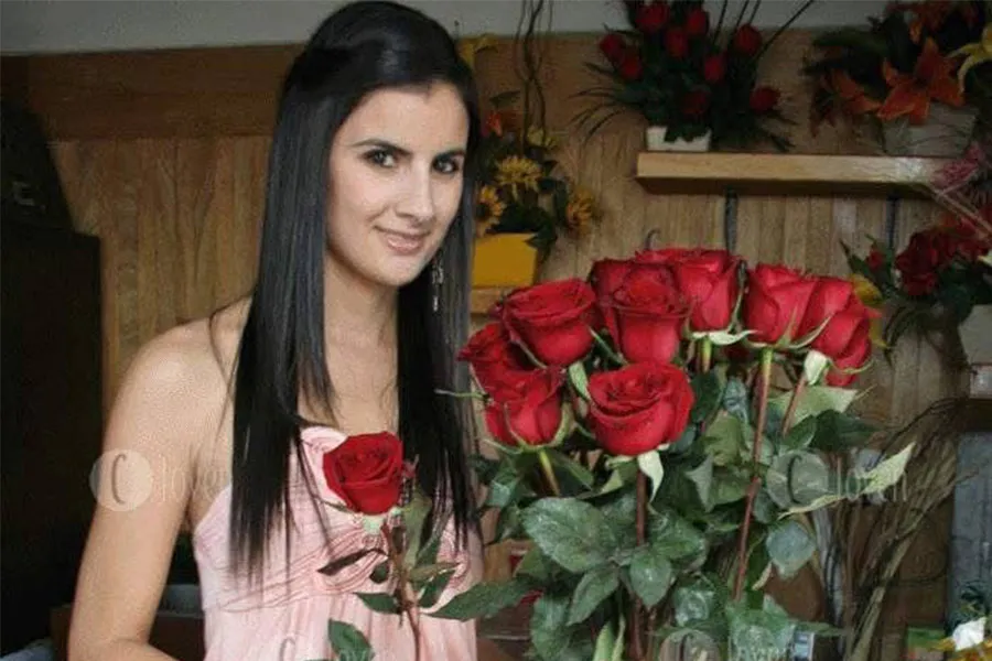 Persona sosteniendo arreglo de flores.