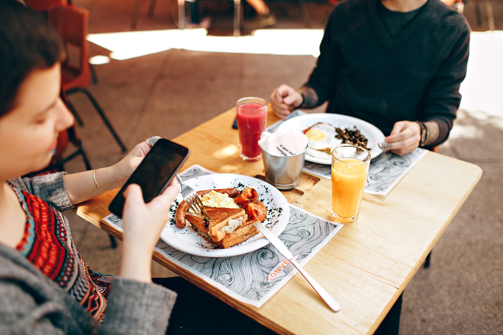 Dos personas frente a frente sentados a la mesa con comida