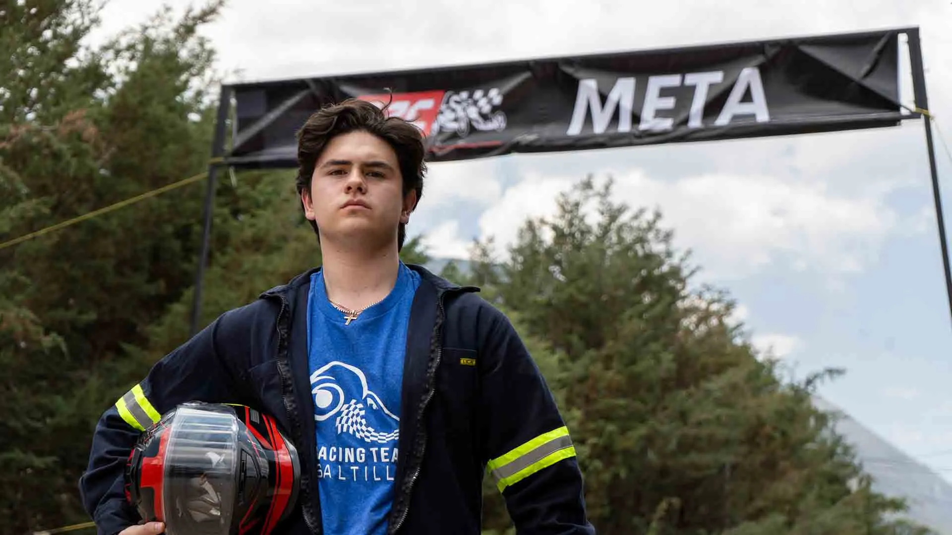 alumno piloto de carreras de gravedad posa frente a la linea meta en pose victoriosa