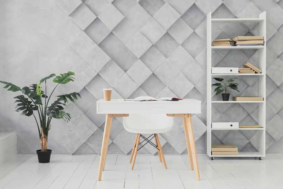 Espacio de trabajo con una planta en un librero y otra planta a un lado del escritorio