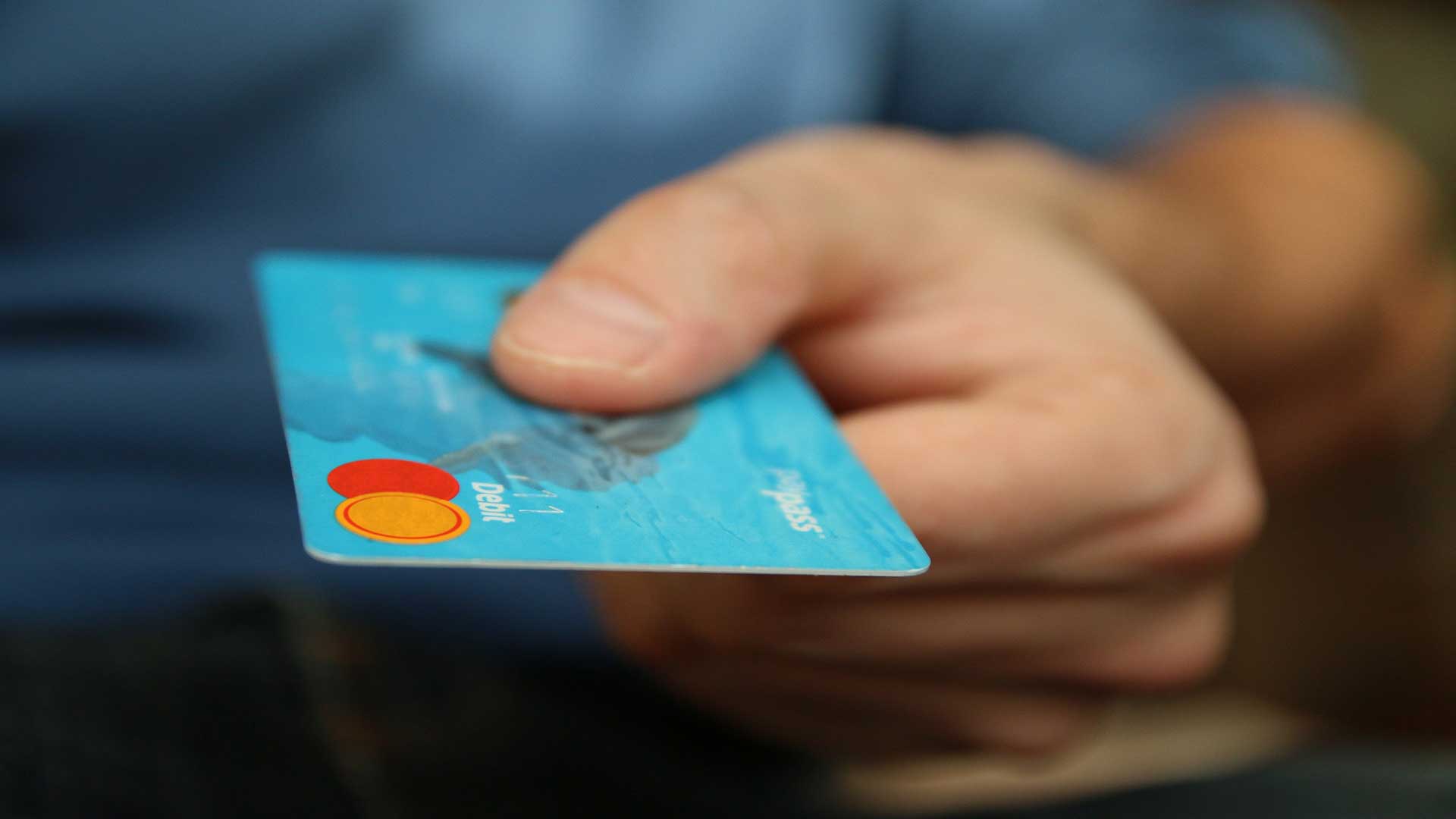 Persona entregando tarjeta de crédito para pagar.