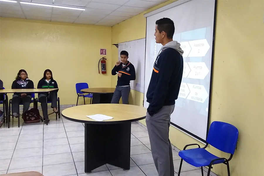 Sebastián frente a un grupo de alumnos, presentando una conferencia de PERMA