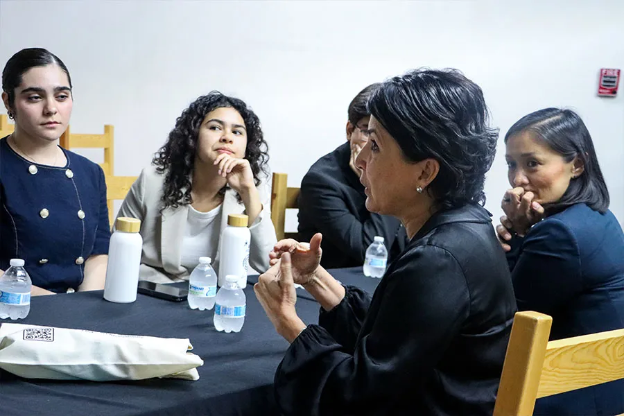5 personas conversando sentados en una mesa.