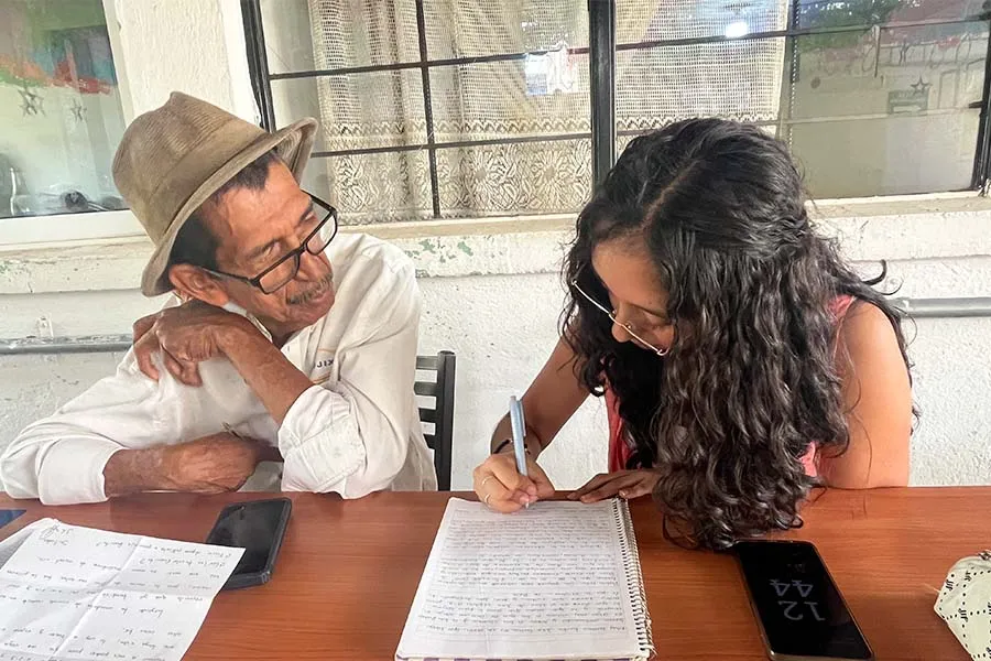 Valeria ayuda a un adulto mayor a escribir su carta
