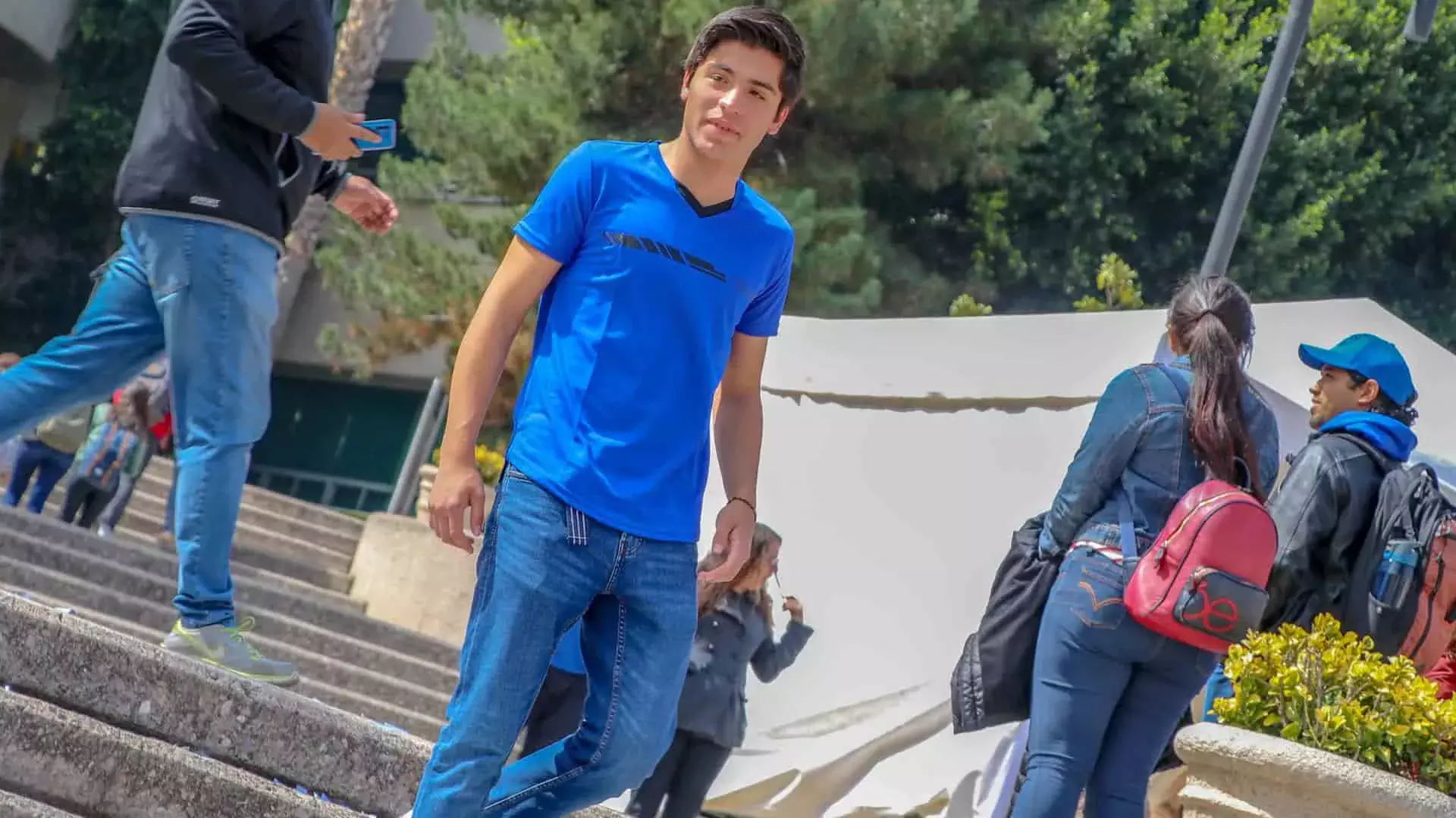 Chico modelando playera deportiva azul con tec escrito en negro