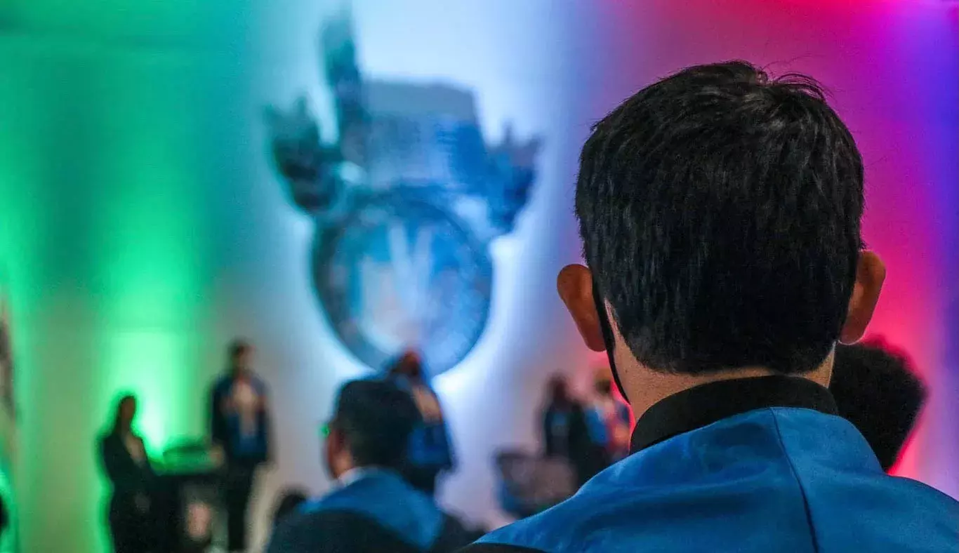 Alumno graduado admirando bandera de México