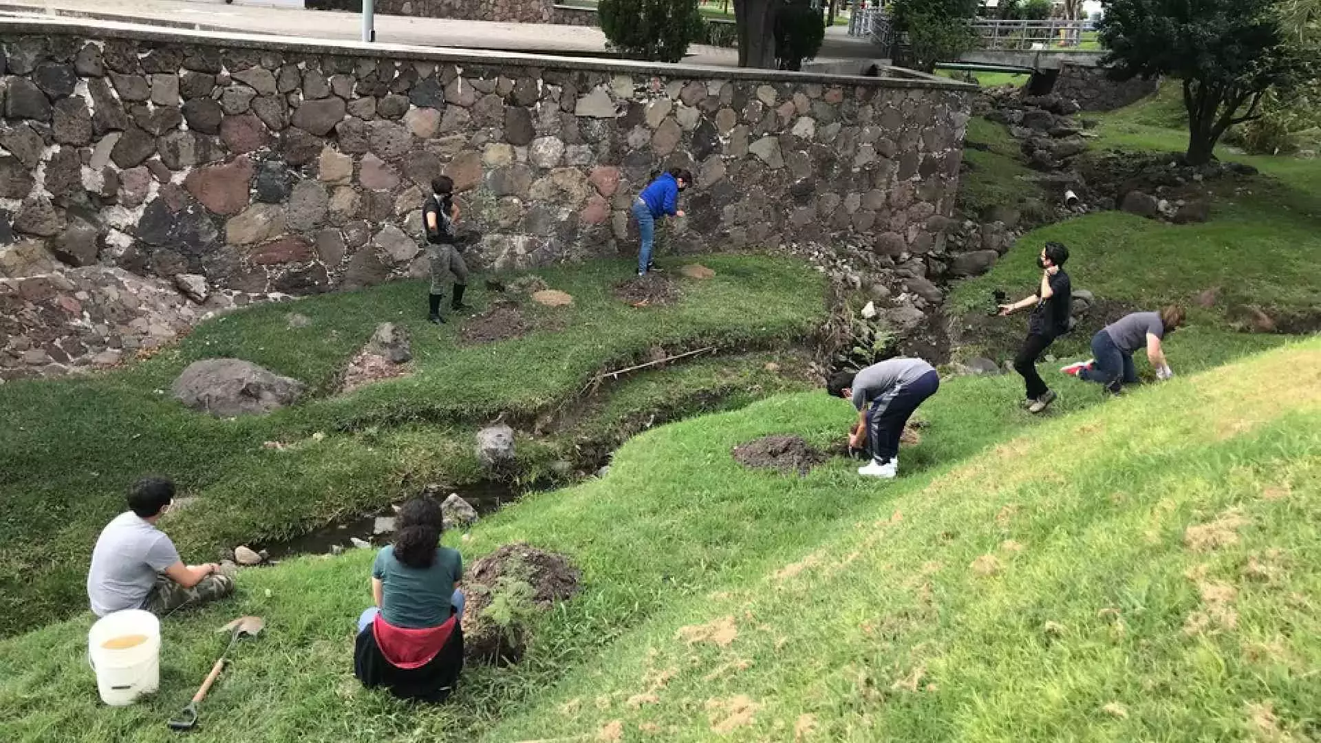 Plantando a las orillas del "río" del campus.