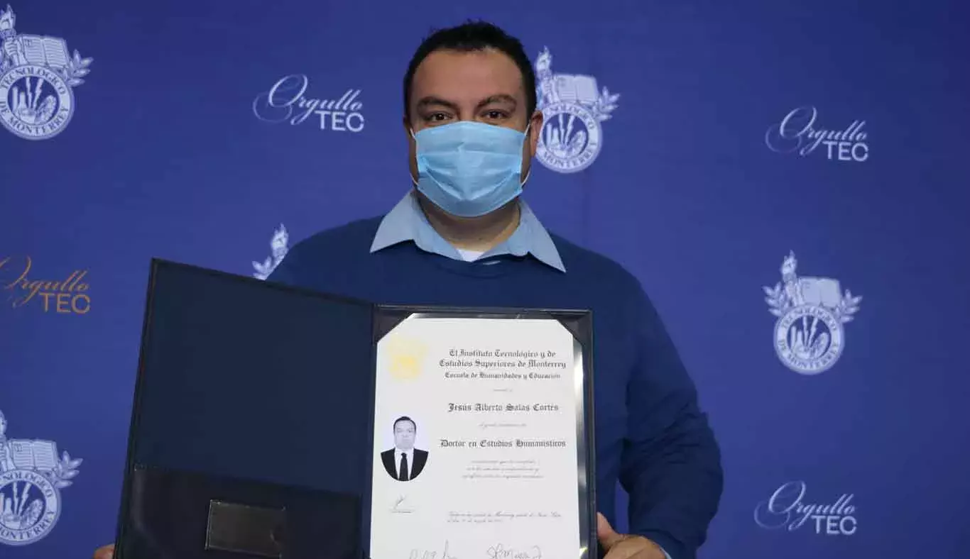 Un egresado de doctorado posó para la foto con su título.