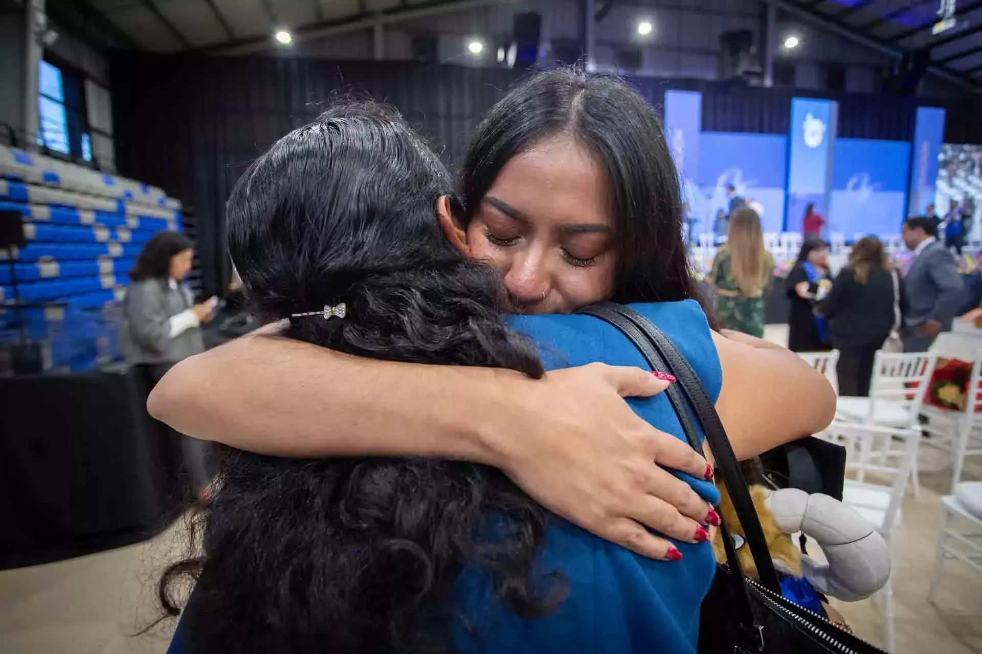 Madre y estudiante graduada abrazándose