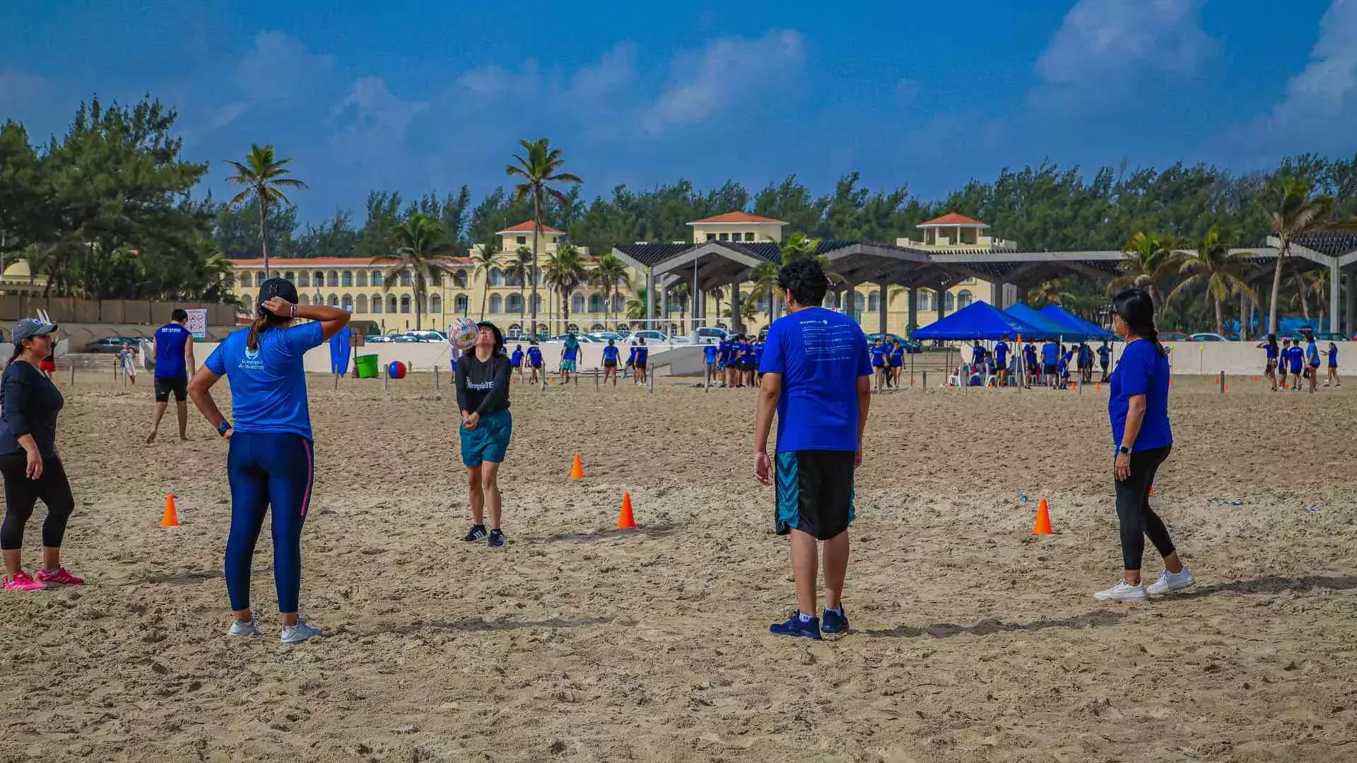 Alumnos jugando voleibol en la playa