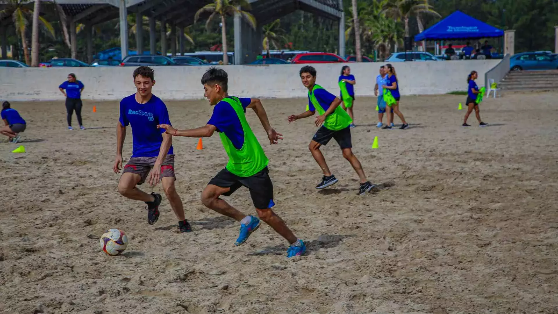 Grupo de alumnos jugando fútbol en la playa