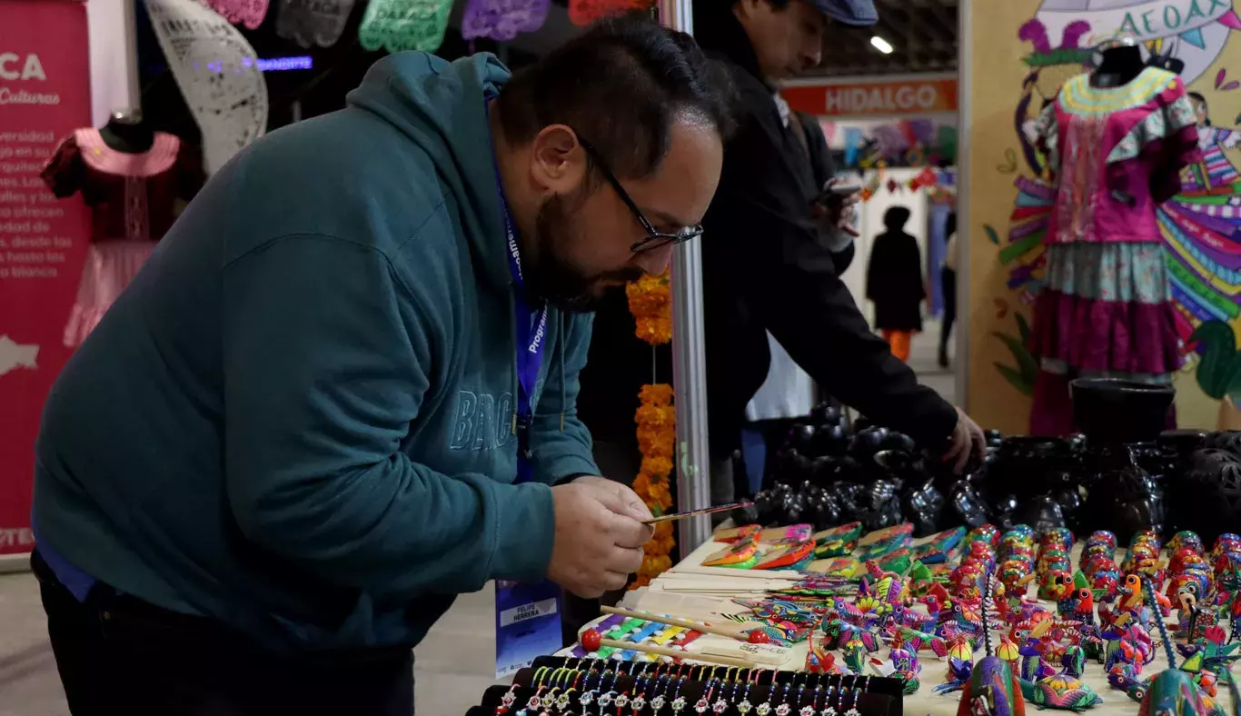 Un hombre viendo artesanías en EXPOTEC.