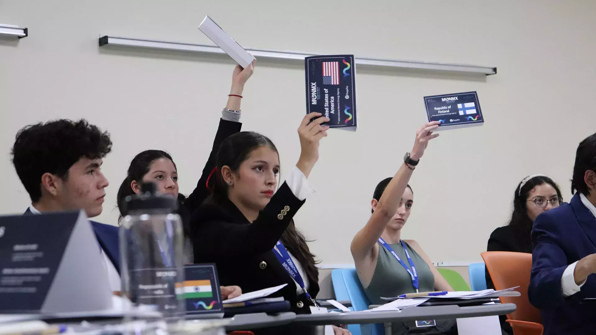 Estudiantes levantan la mano para participar