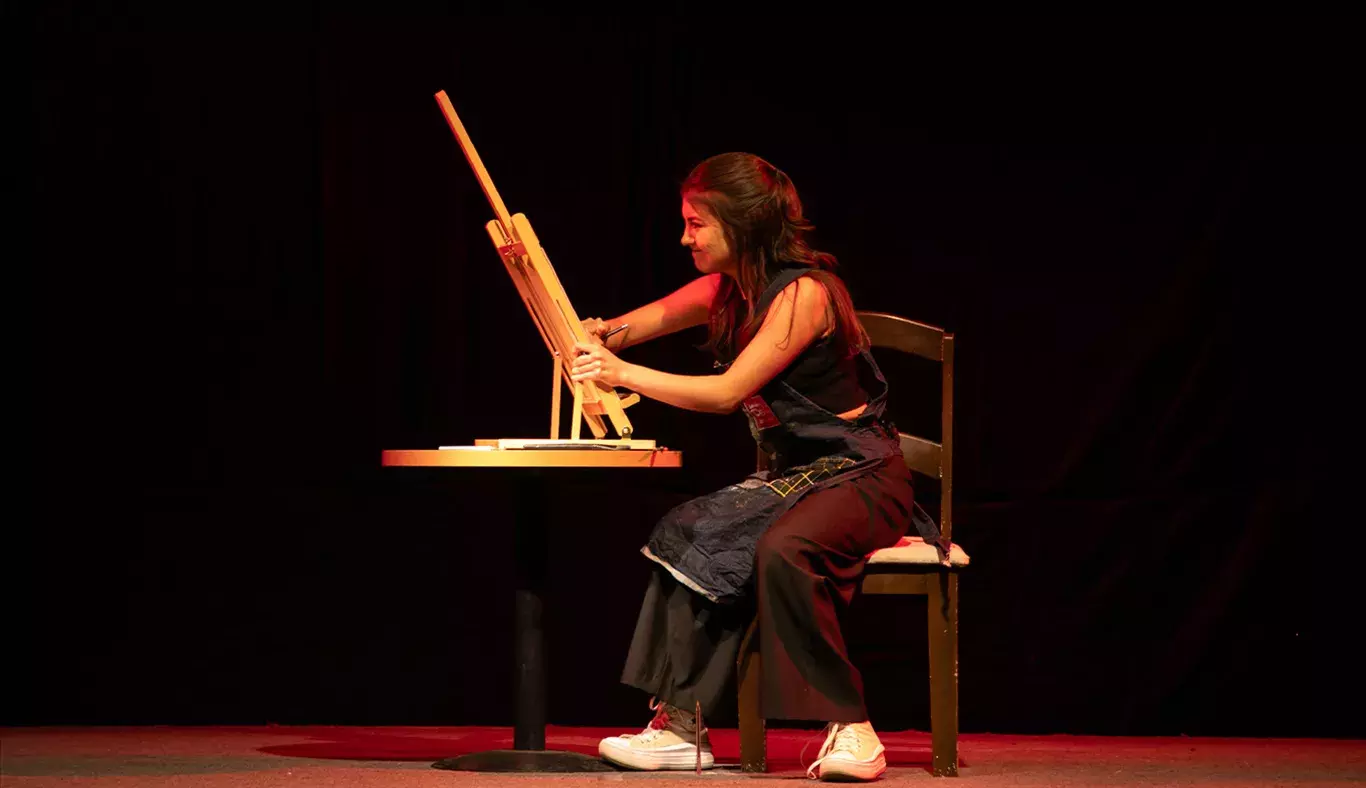 Estudiante del representativo de teatro pintando un cuadro agresivamente en su monólogo
