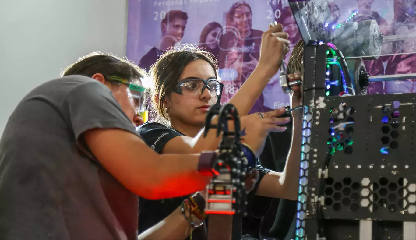 Jovenes trabajndo en su robot.