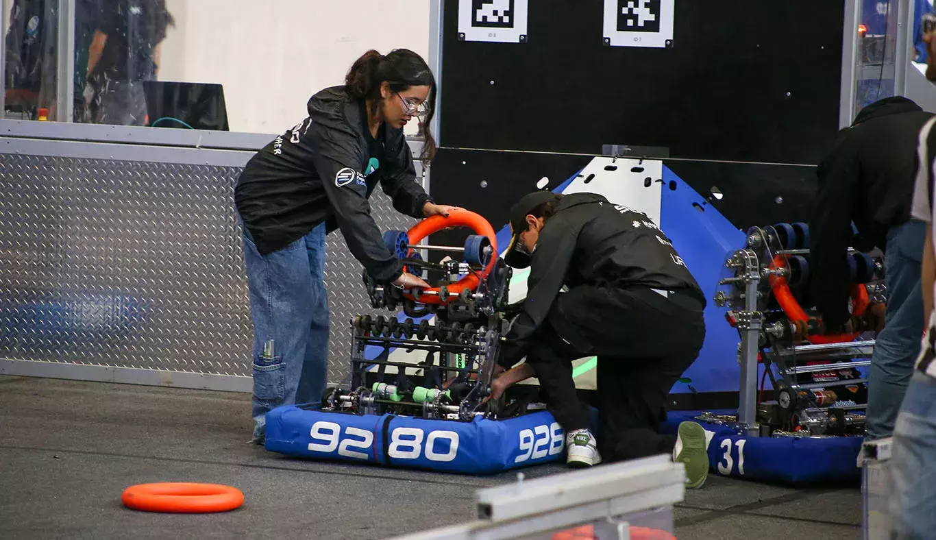 Alumnos colocando su robot en posición.