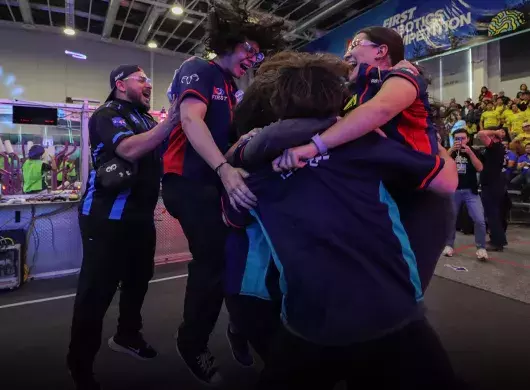 Equipo salta y se abaraza en un momento de celebración. 