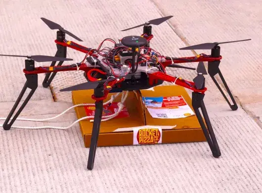 El dron "Alexa" sostiene una pizza.