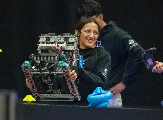 Alumna sonriendo en torneo de robótica