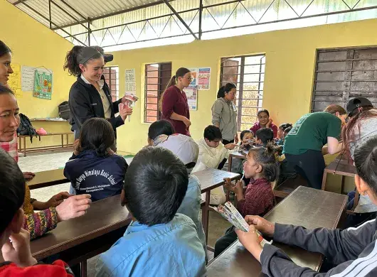 alumnos sentados en escritorios viendo lección