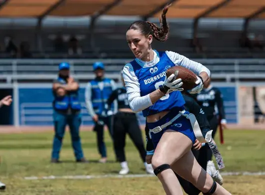 Jugadora de tochito bandera de Borregos Laguna corre hacia la zona de anotación con el balón en mano