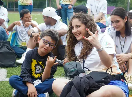 Participante y voluntaria sonriendo en campamento Vive Extremo