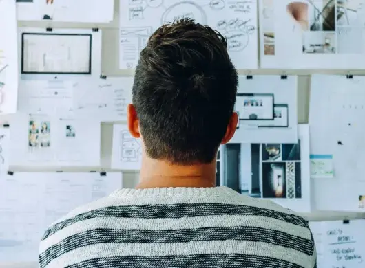 Joven ante un muro de diagramas y planeación