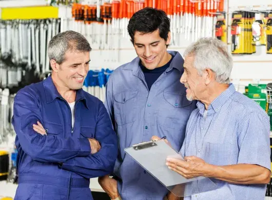 Tres generaciones de hombres platicando en una ferretería, concepto de una empresa familiar