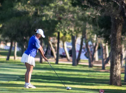 Jugadora preparando su tiro en uno de los hoyos del recorrido.