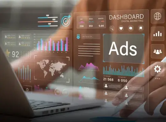 Closeup de una laptop y un cuerpo humano sentado frente a ella, con gráficas semitransparentes superpuestas que muestran métricas de publicidad.