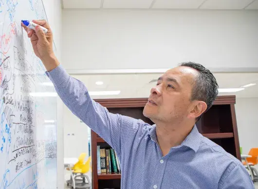 Profesor de la Escuela de Negocios del Tec de Monterrey campus Laguna utiliza pintarrón para hacer apuntes