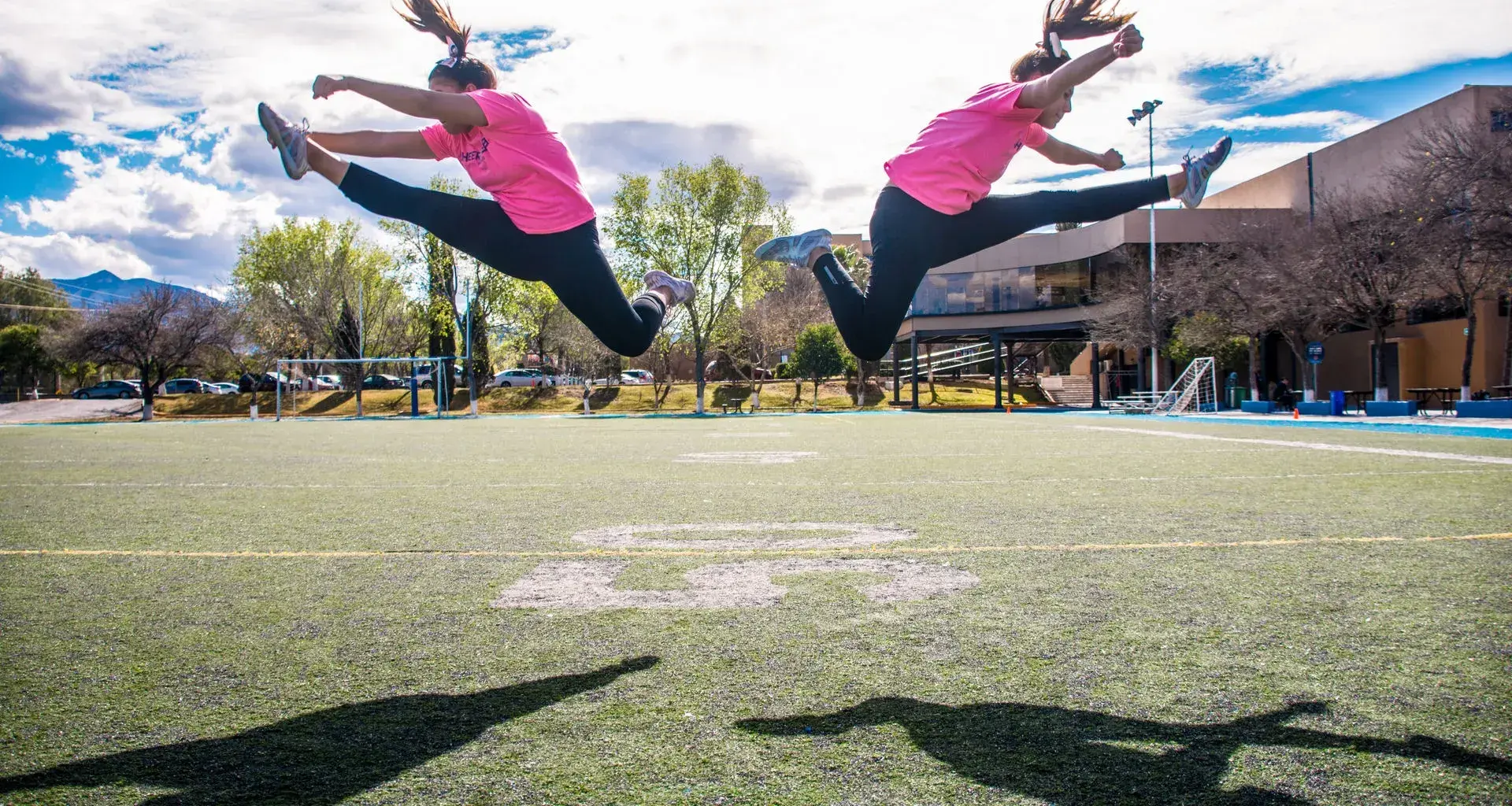 Dos mujeres haciendo acrobacias en una cancha de fútbol americano