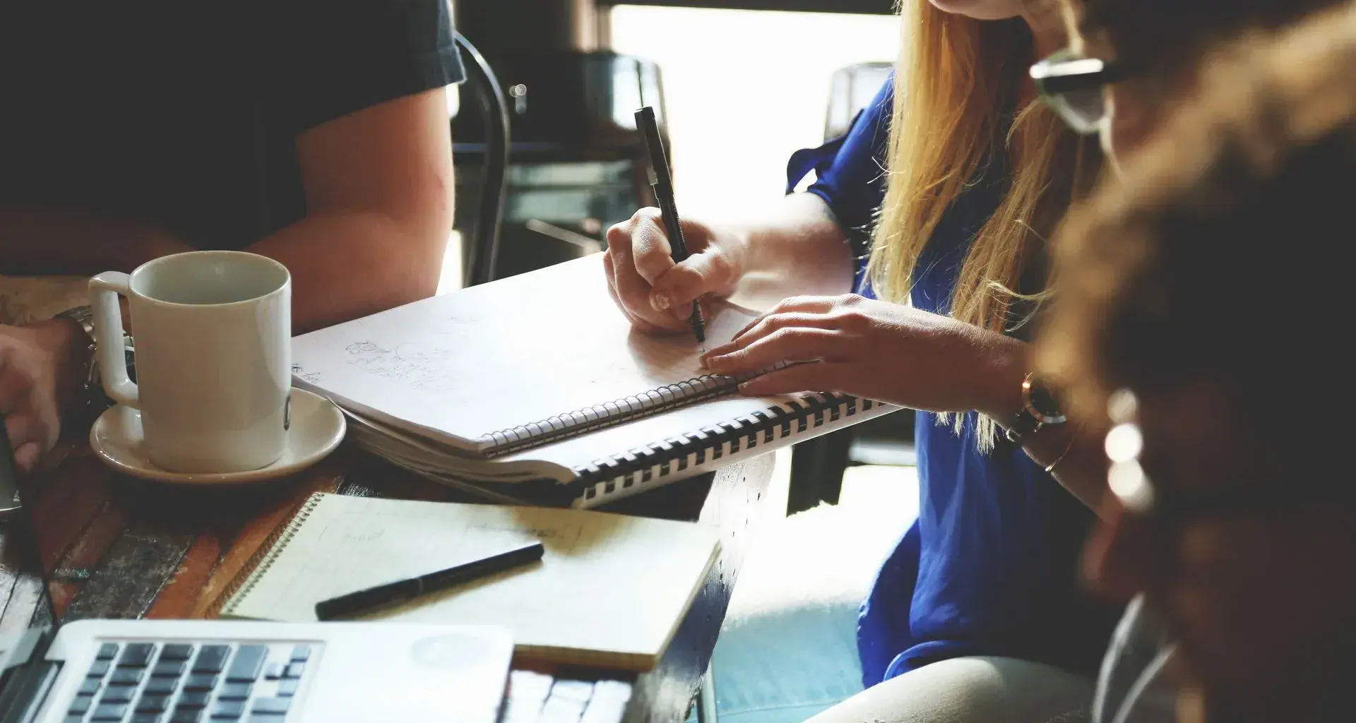 Jóvenes estudiantes en mesa de trabajo.