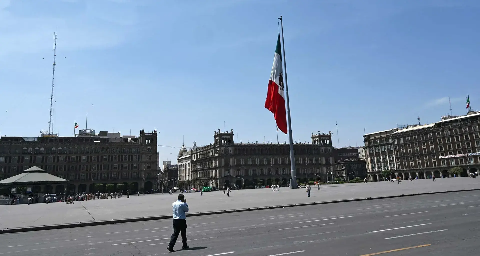 Vista del Zócalo de la Ciudad de México, con una persona caminando por su calle ante el vacío de vehículos