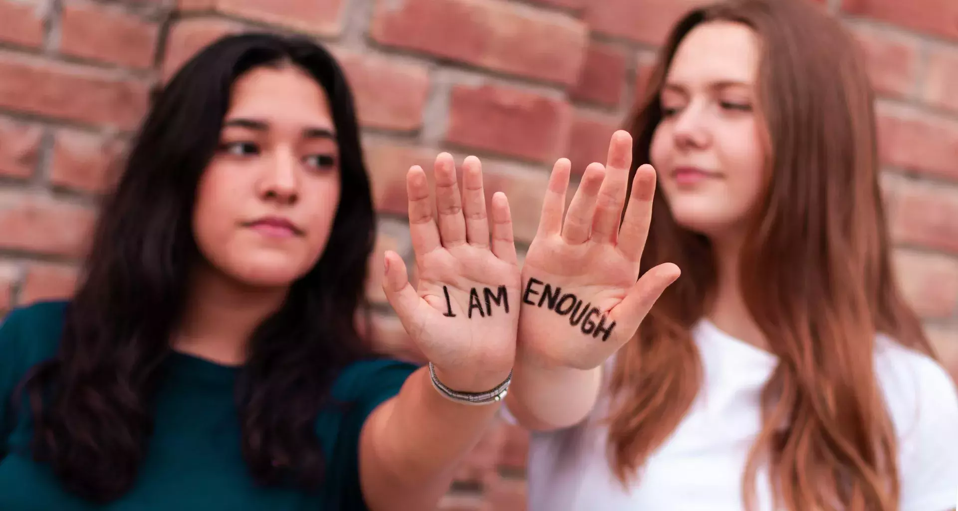 Alumnas mostrando frase escrita en sus manos