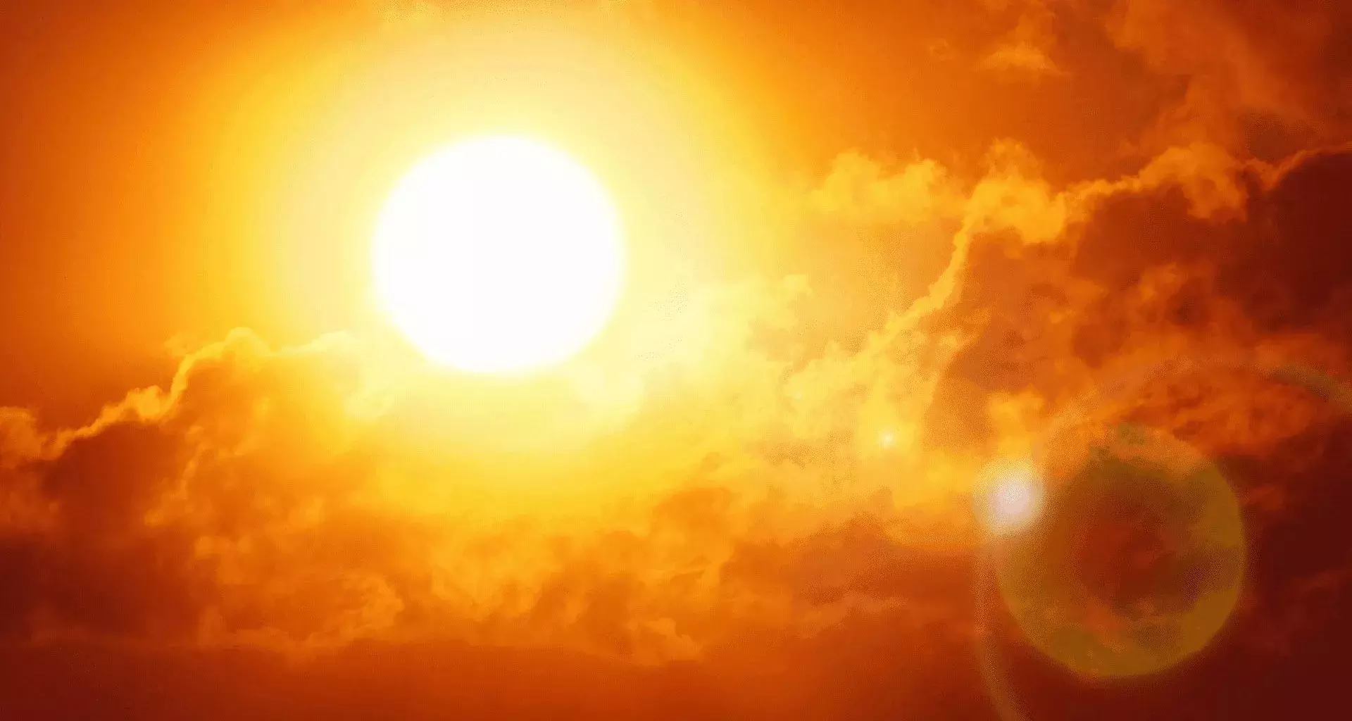 Fotografía del sol reflejando sus rayos en el cielo con tonalidades rojizas/naranjas por altas temperaturas.