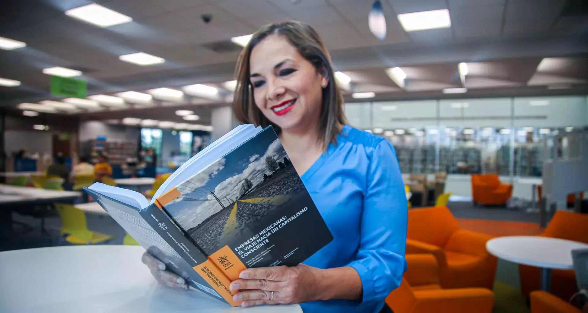 Adriana Morales leyendo un libro en el que participó como coautora