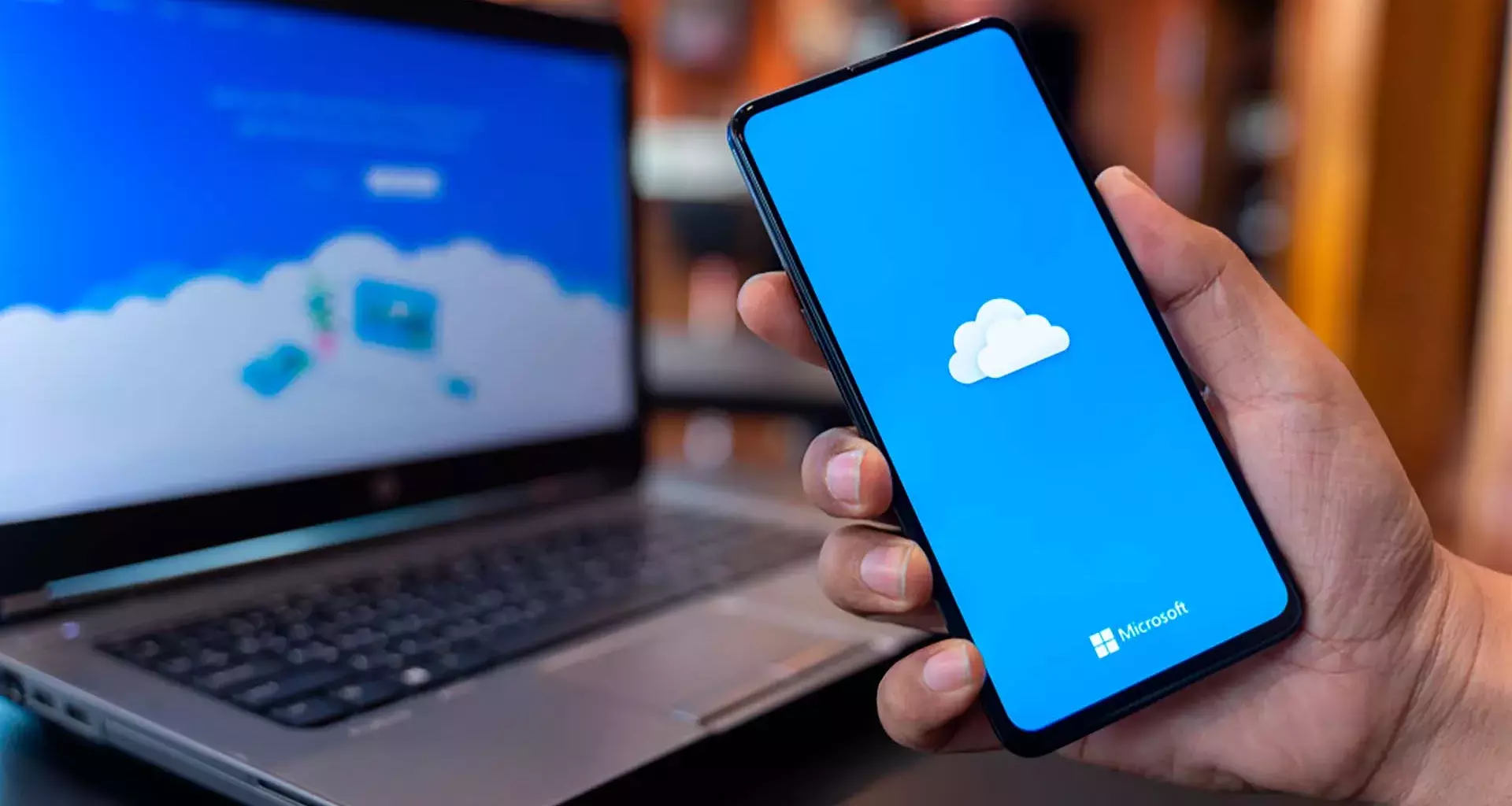 Celular y computadora con el logo de la herramienta OneDrive