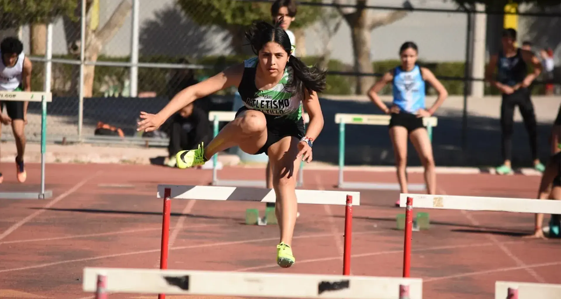 Atleta Tec corriendo en la pista con vallas