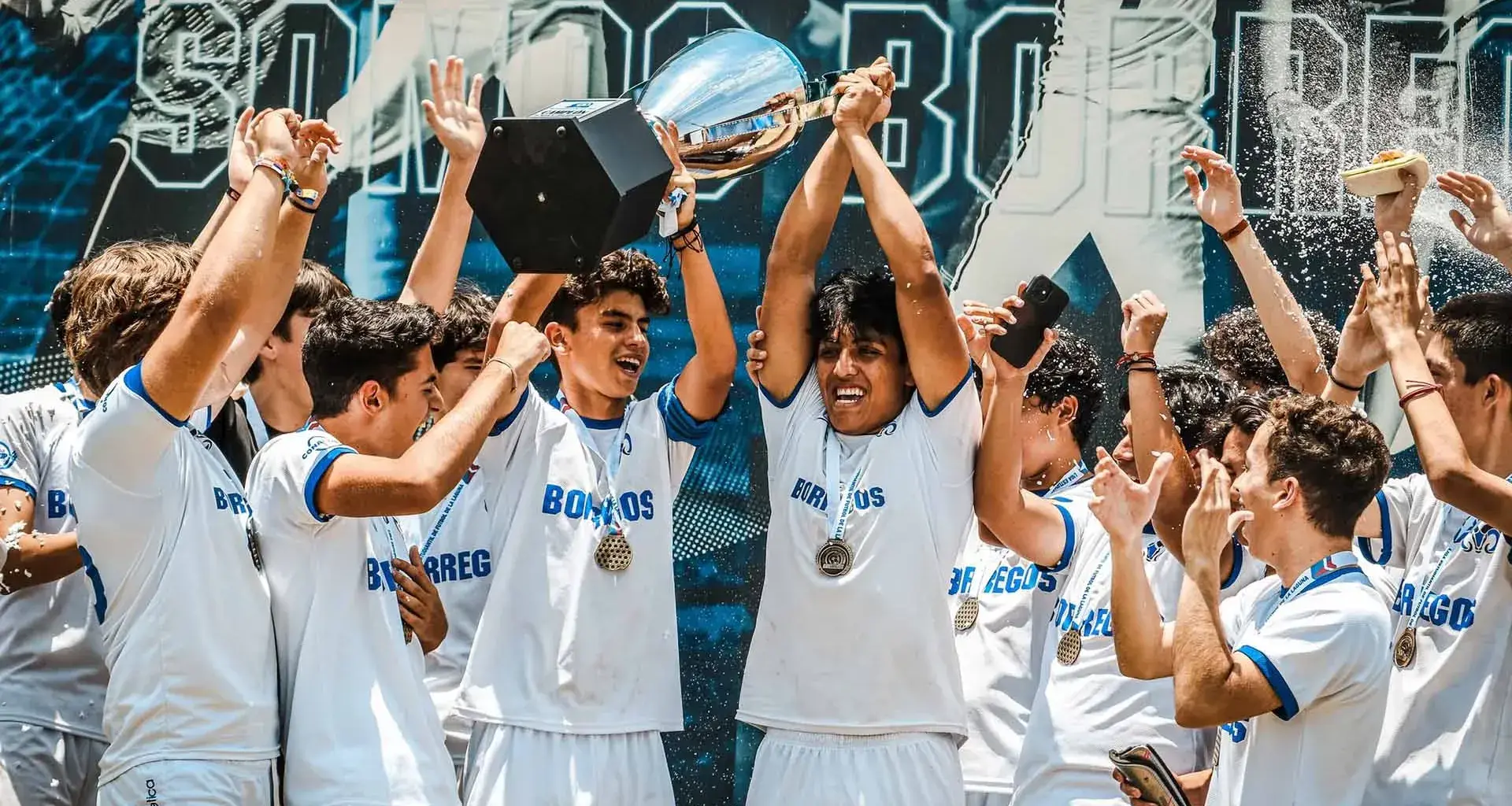 Jugadores de futbol soccer de Borregos Laguna juvenil festejan y levantan un trofeo