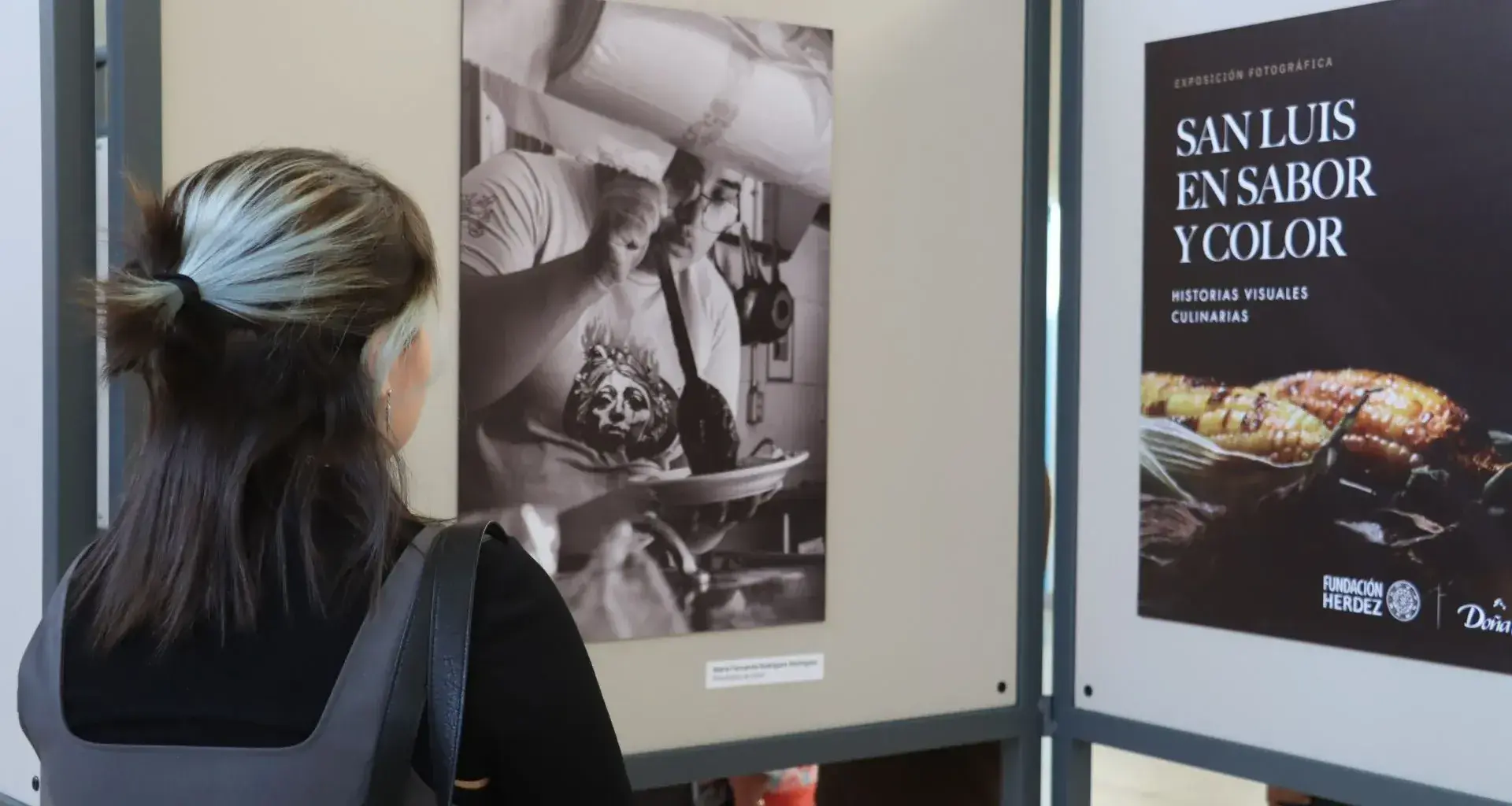 alumna observando fotografías en la exposición 