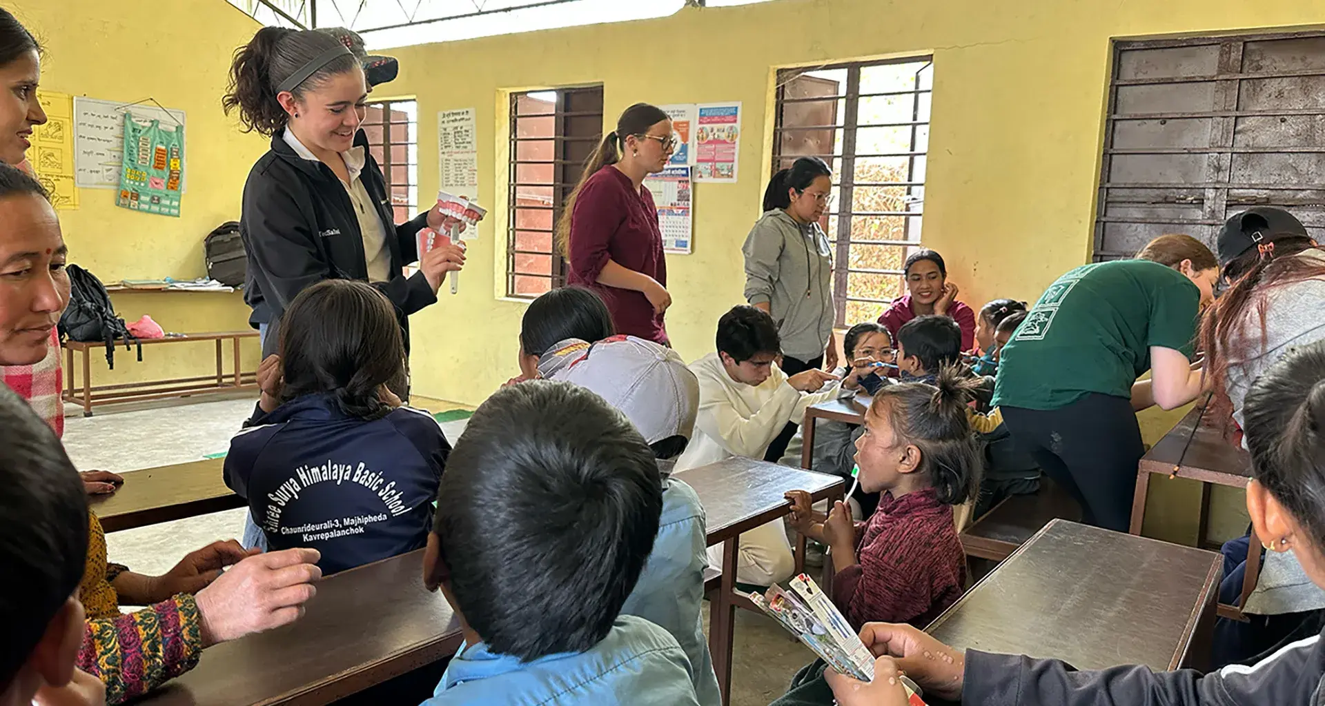 alumnos sentados en escritorios viendo lección