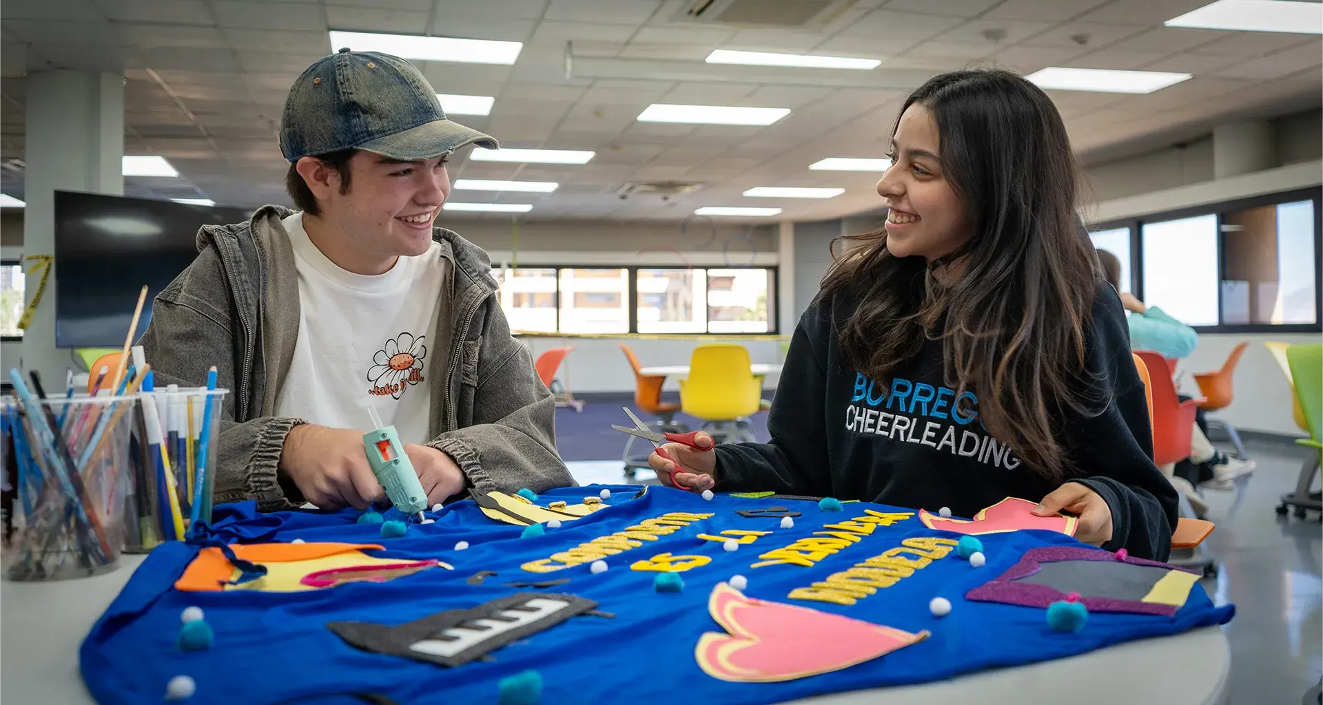 Dos alumnos sonriendo y mirándose.